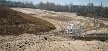 Große Baustelle mit Erdarbeiten und großen Fahrzeugen im Industriegebiet